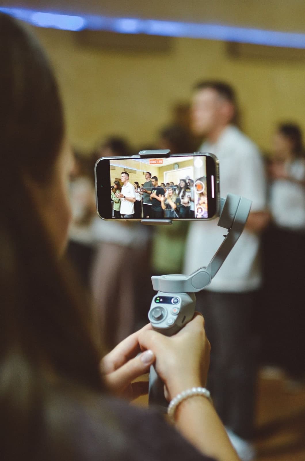 Content creator filming guests on the dance floor with a phone on a gimbal